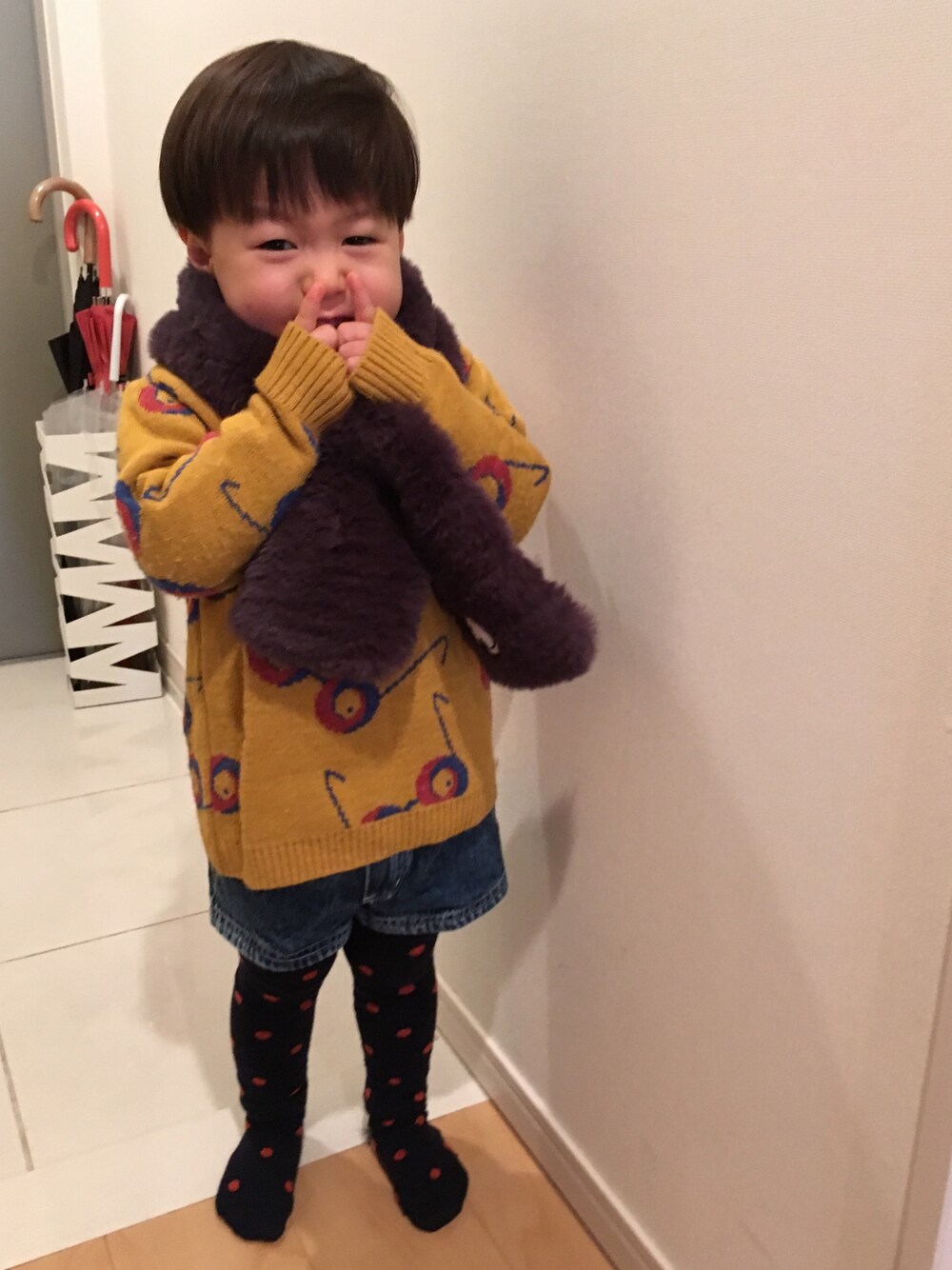 イエロー系のニット/セーター、ブルー系のパンツ、ブルー系のタイツ/ストッキングを着用したキッズの冬コーディネートの1枚目の写真