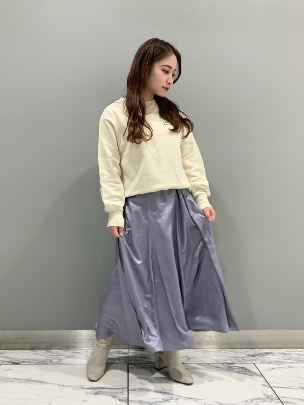 ホワイト系のTシャツ/カットソー、グレー系のブーツ、ブルー系のスカートを着用したレディースの冬コーディネートの1枚目の写真