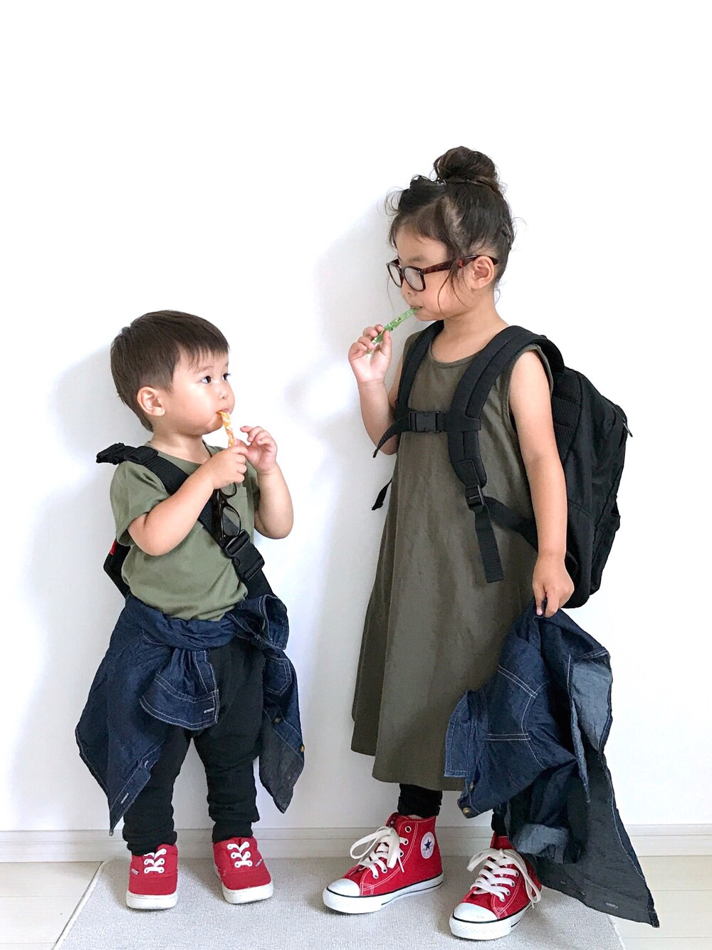 グリーン系のワンピース、ブルー系のシャツ/ブラウス、レッド系のスニーカーを着用したキッズの夏コーディネートの1枚目の写真