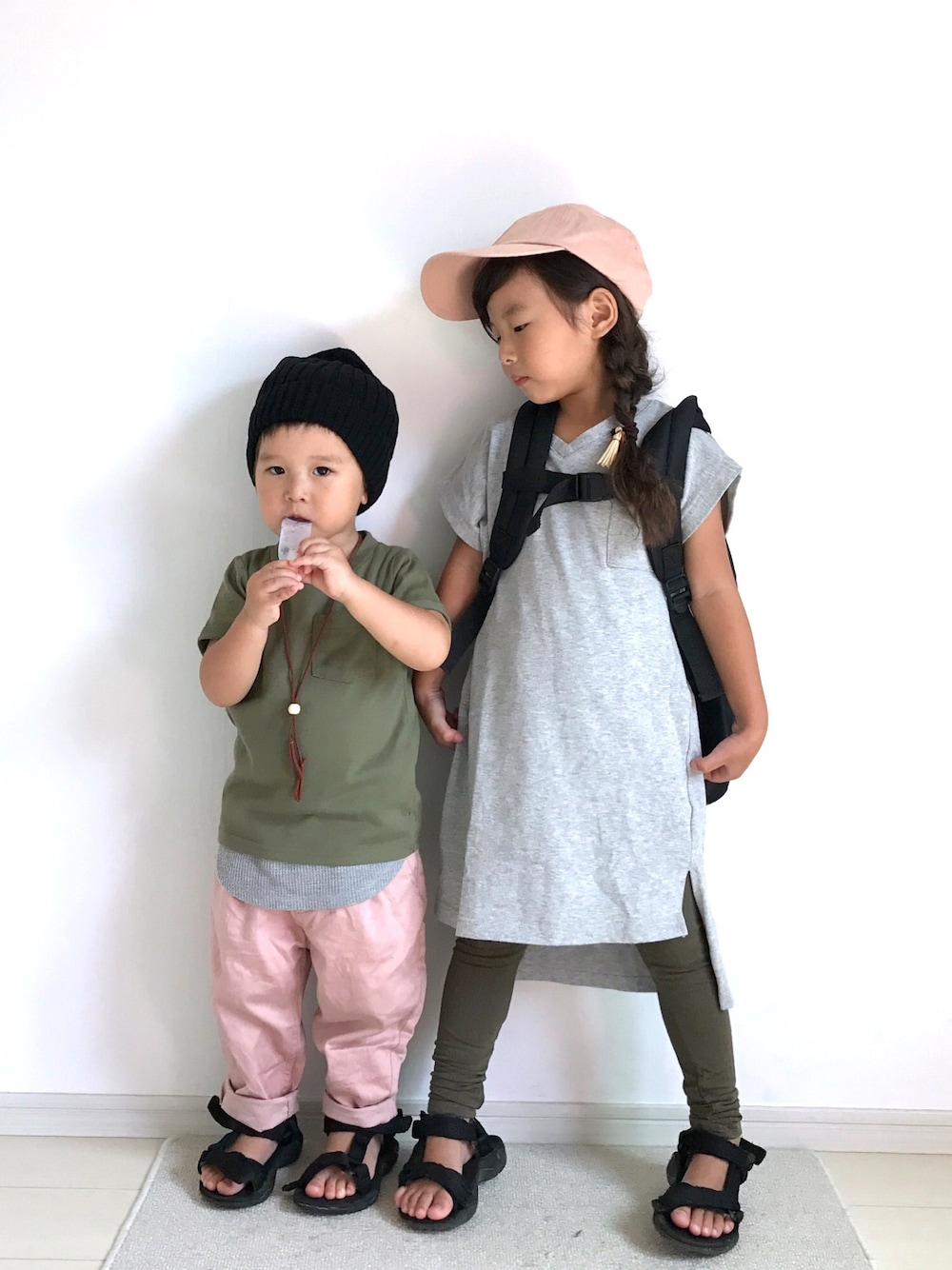 グレー系のワンピース、サンダル、グリーン系のTシャツ/カットソーを着用したキッズの秋コーディネートの1枚目の写真