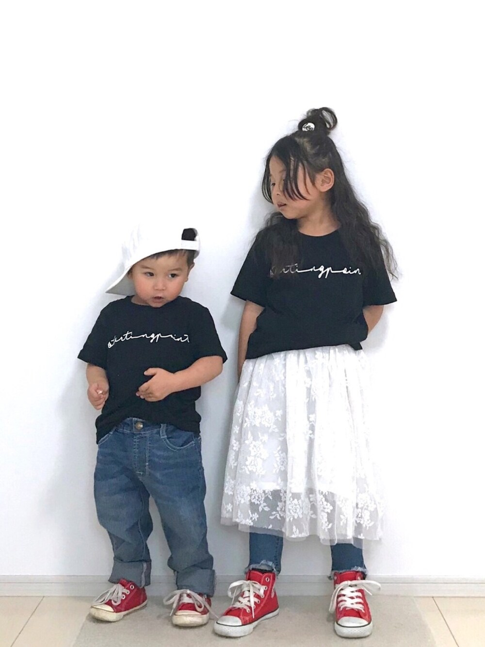 ブラック系のTシャツ/カットソー、ブルー系のデニムパンツ、レッド系のスニーカーを着用したキッズの春コーディネートの1枚目の写真