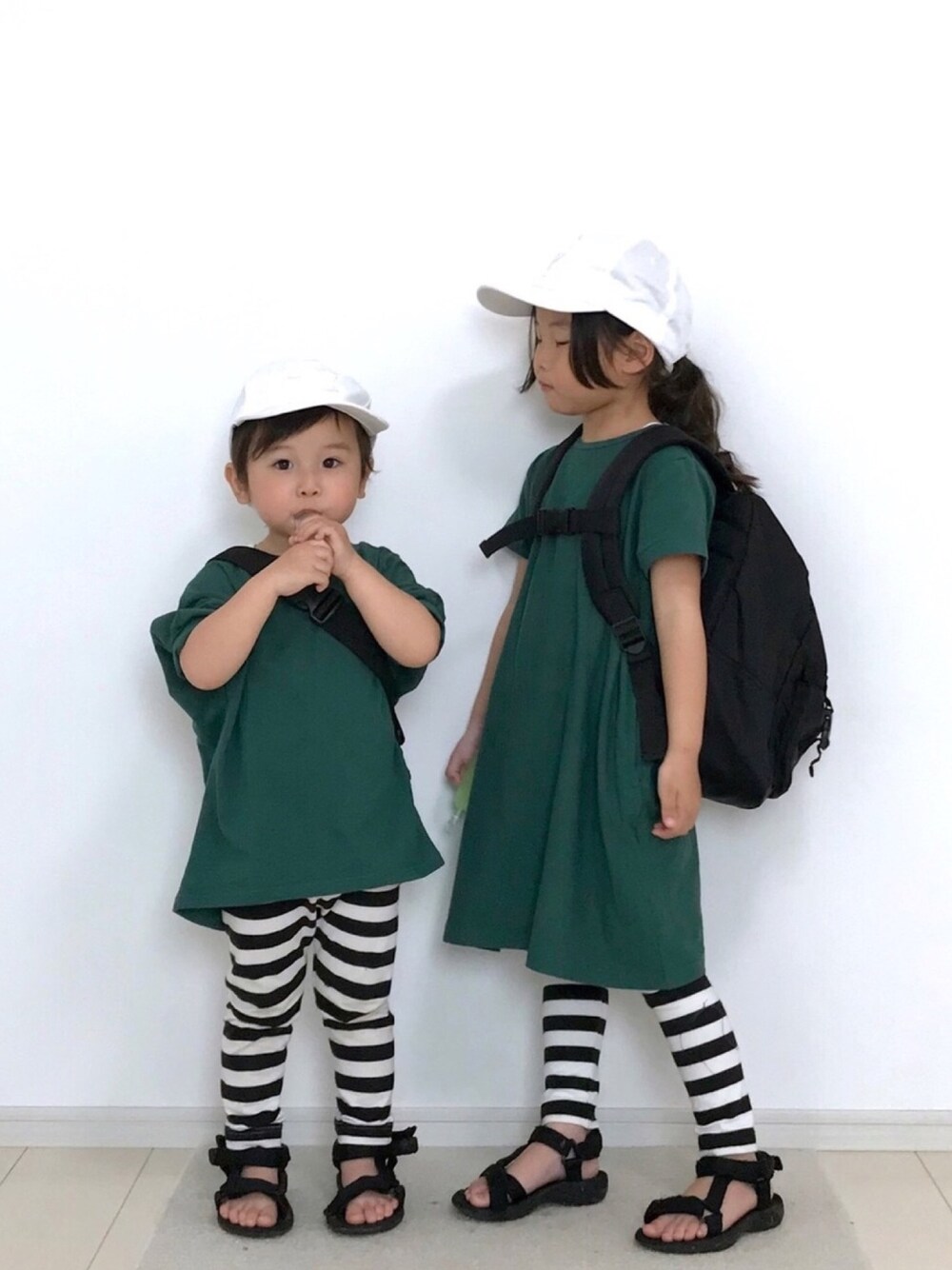 グリーン系のワンピース、グリーン系のTシャツ/カットソー、ブラック系のレギンス/スパッツを着用したキッズの春コーディネートの1枚目の写真