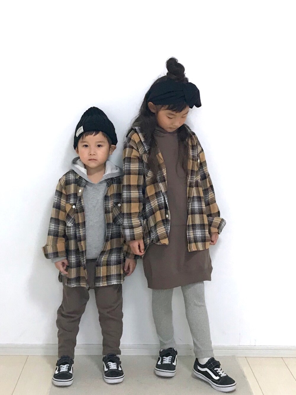 ベージュ系のシャツ/ブラウス、ブラウン系のワンピース、ブラック系のスニーカーを着用したキッズの冬コーディネートの1枚目の写真