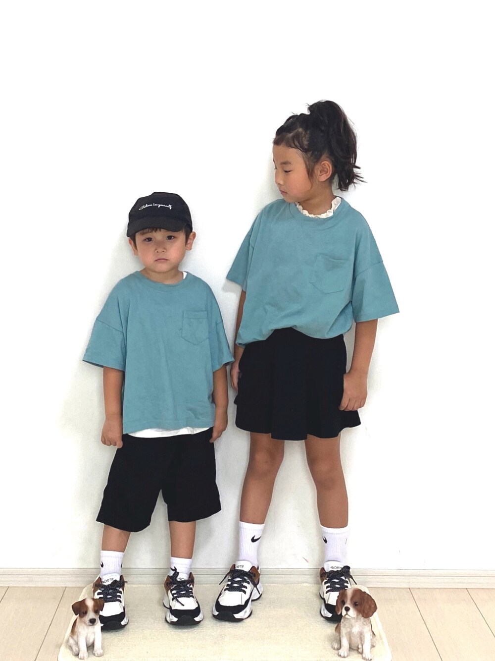 グリーン系のTシャツ/カットソー、ホワイト系のタンクトップ、ブラック系のスカートを着用したキッズの春コーディネートの1枚目の写真
