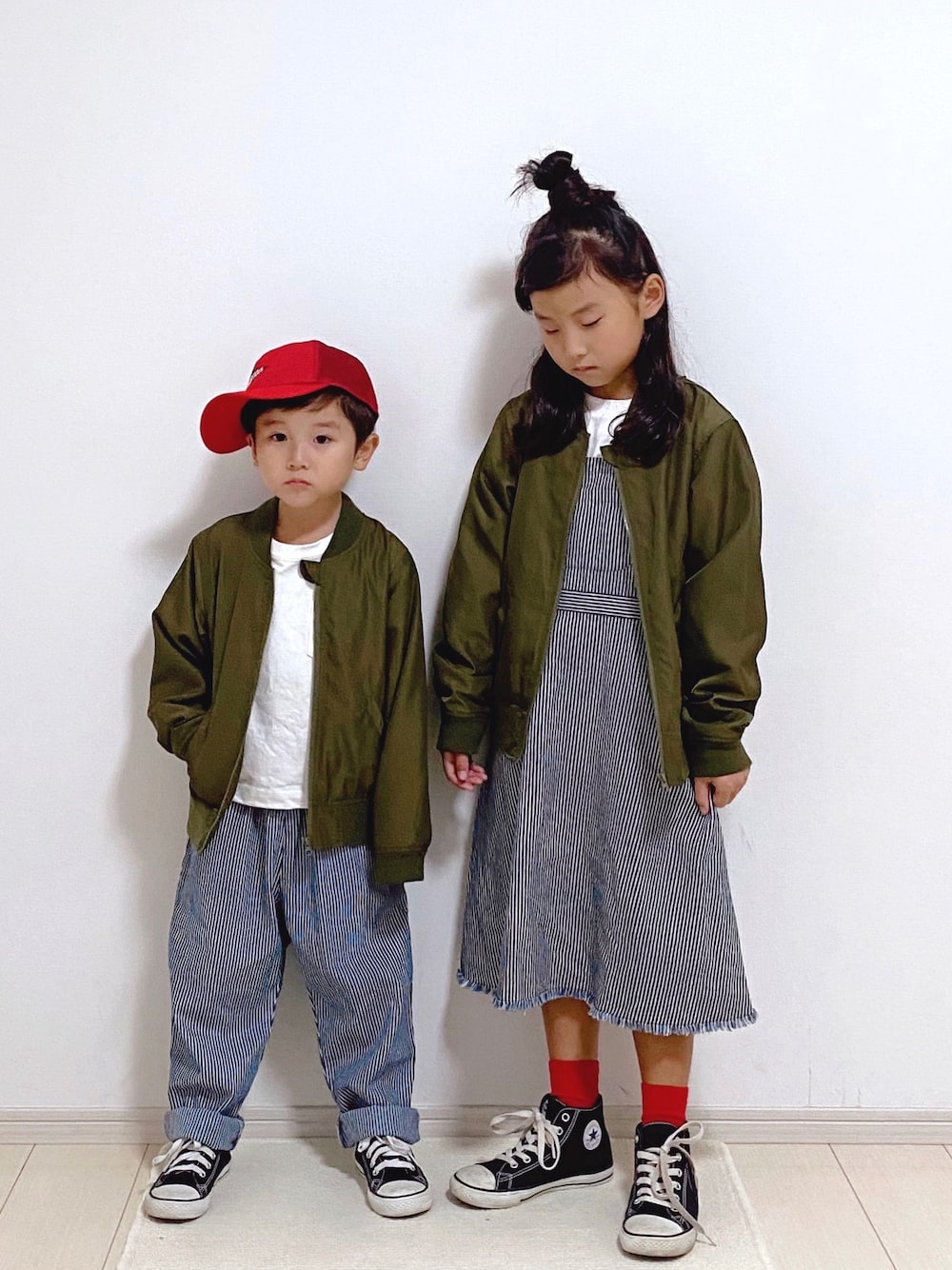 グリーン系のMA-1、ホワイト系のTシャツ/カットソー、ブルー系のサロペット/オーバーオールを着用したキッズの冬コーディネートの1枚目の写真