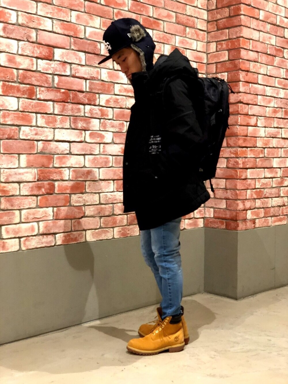 ブラック系のブルゾン、ブルー系のデニムパンツ、ブラック系のバックパック/リュックを着用したメンズの冬コーディネートの1枚目の写真