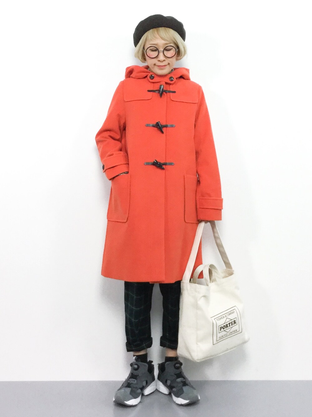 オレンジ系のダッフルコート、ホワイト系のトートバッグ、ブラウン系のハンチング/ベレー帽を着用したレディースの秋コーディネートの1枚目の写真