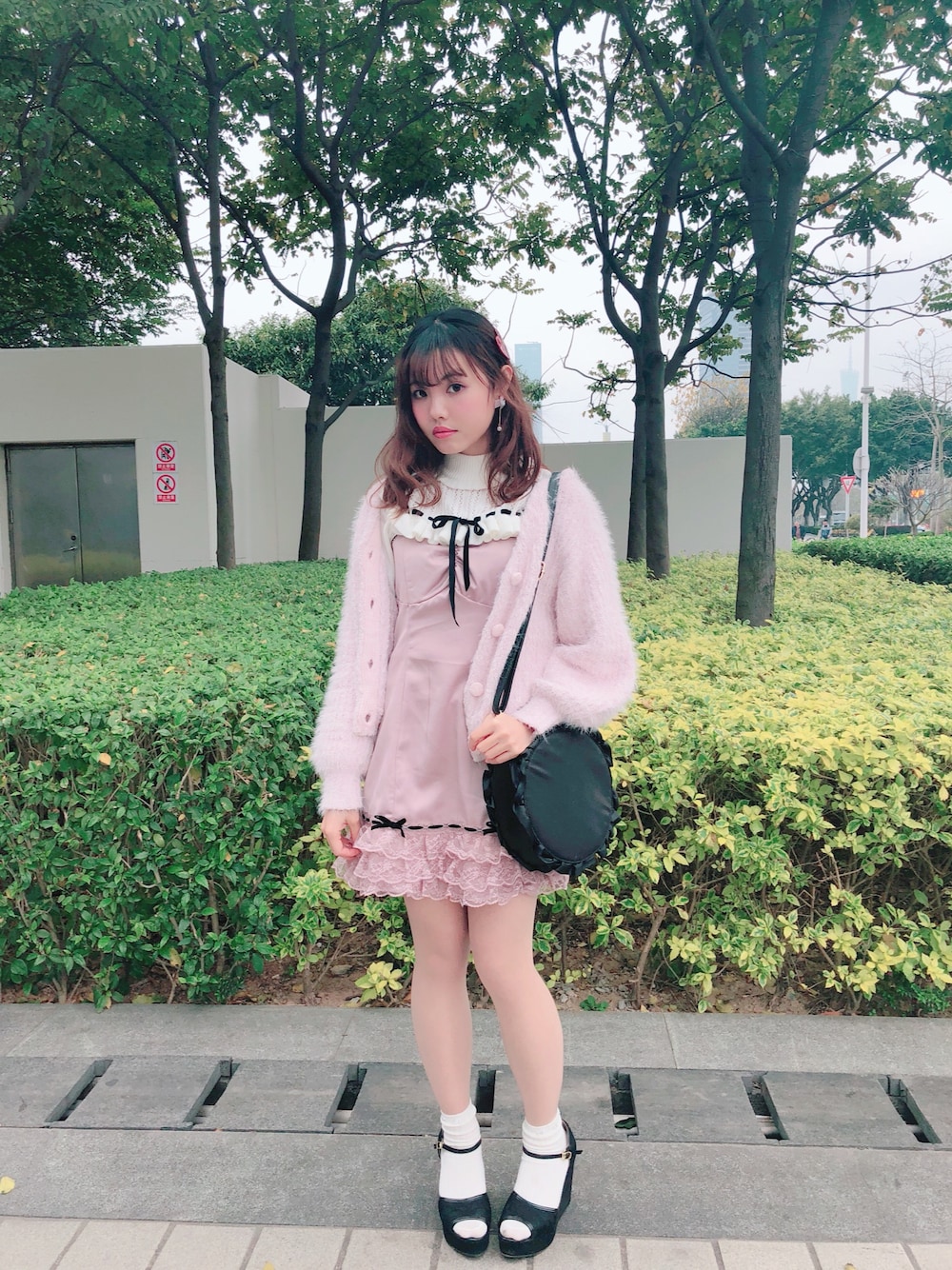 ピンク系のカーディガン/ボレロ、ホワイト系のトップス、ピンク系のワンピース/ドレスを着用したレディースの冬コーディネートの1枚目の写真