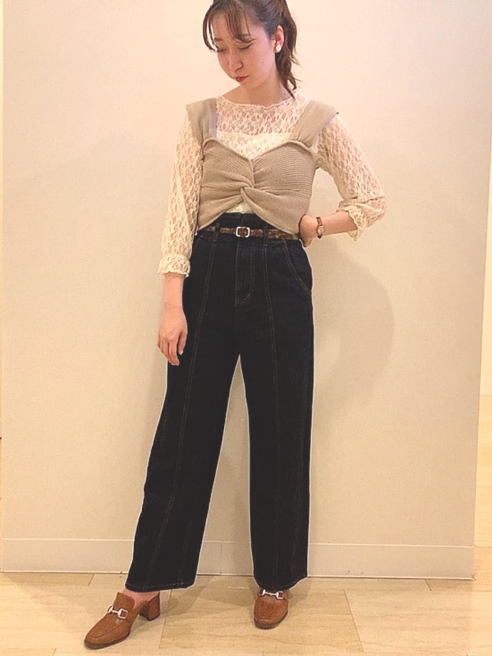 ベージュ系のポロシャツ、ブルー系のデニムパンツを着用したレディースの秋コーディネートの1枚目の写真