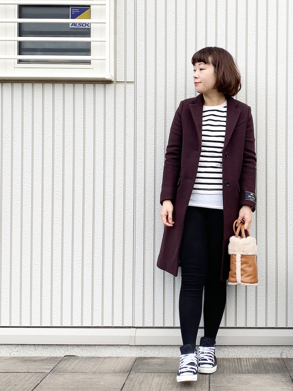 ベージュ系のTシャツ/カットソー、ブラウン系のその他アウター、オレンジ系のショルダーバッグを着用したレディースの冬コーディネートの1枚目の写真