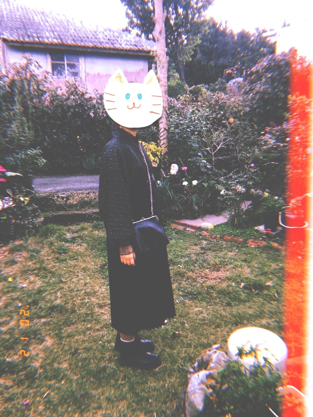 ブラック系のショルダーバッグ、ブラック系のスカート、ブラック系のブーツを着用したレディースの冬コーディネートの1枚目の写真