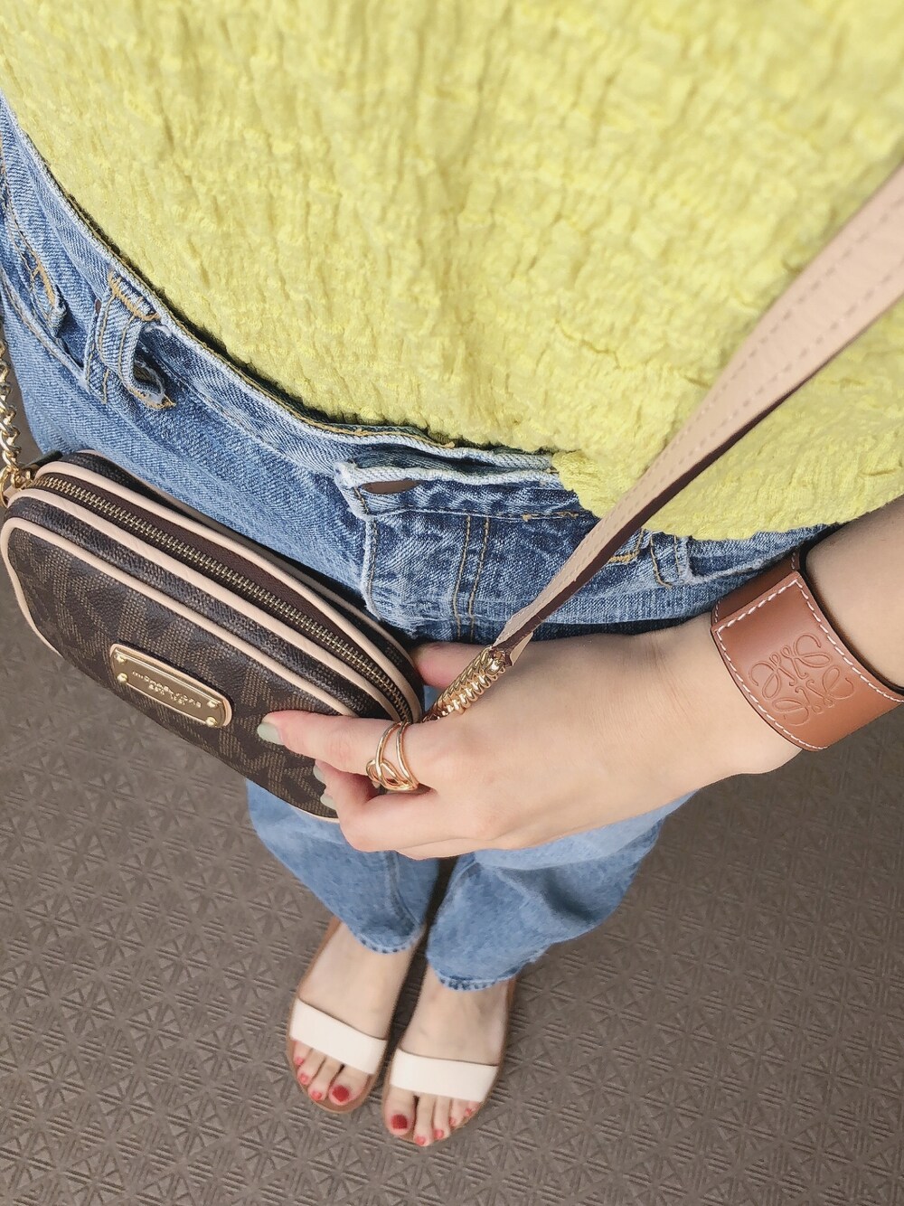 イエロー系のTシャツ/カットソー、ブルー系のデニムパンツ、ベージュ系のサンダルを着用したレディースの夏コーディネートの1枚目の写真