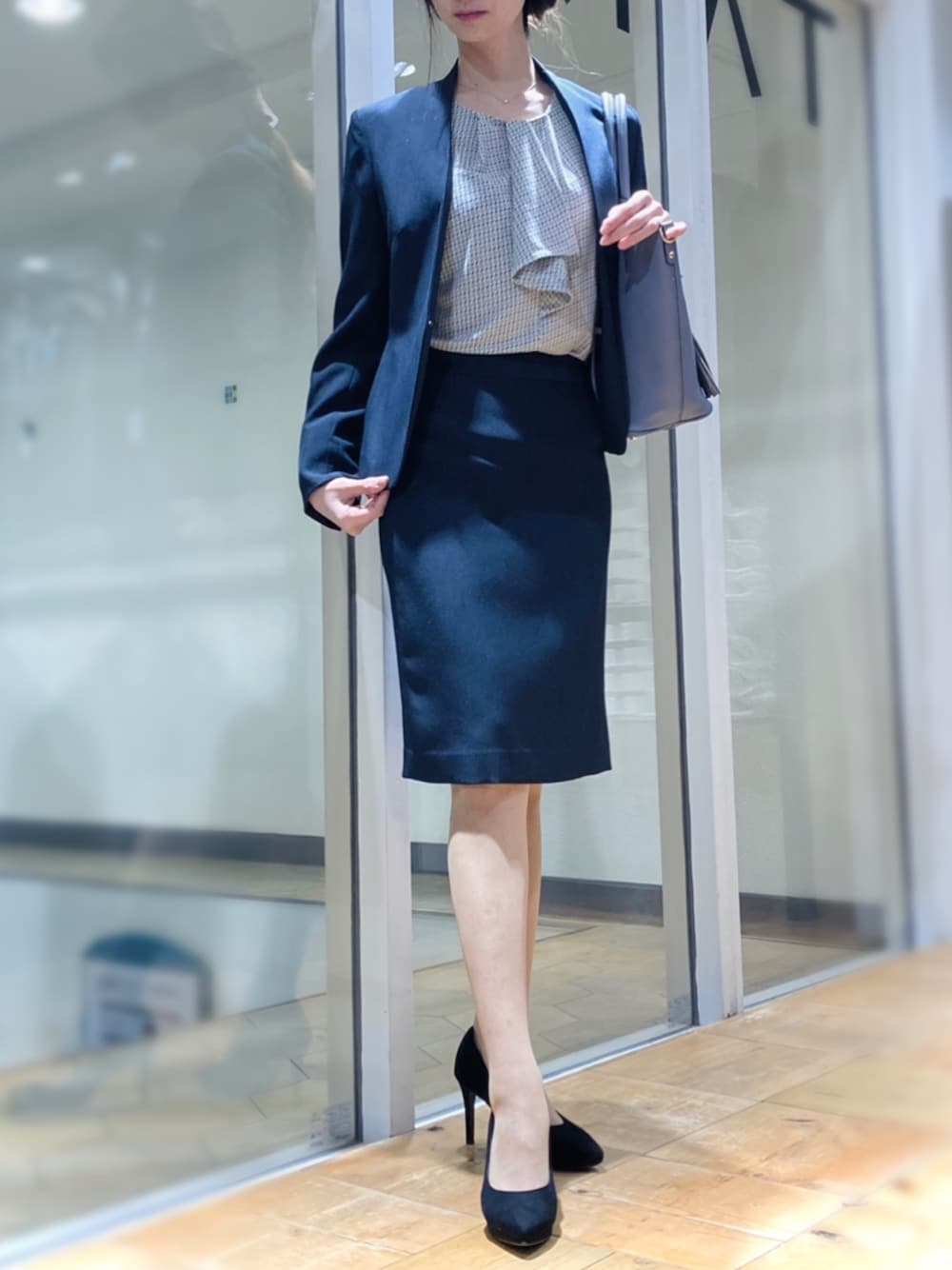 ブルー系のスーツセット、ブルー系のトートバッグ、ホワイト系のTシャツ/カットソーを着用したレディースの春コーディネートの1枚目の写真