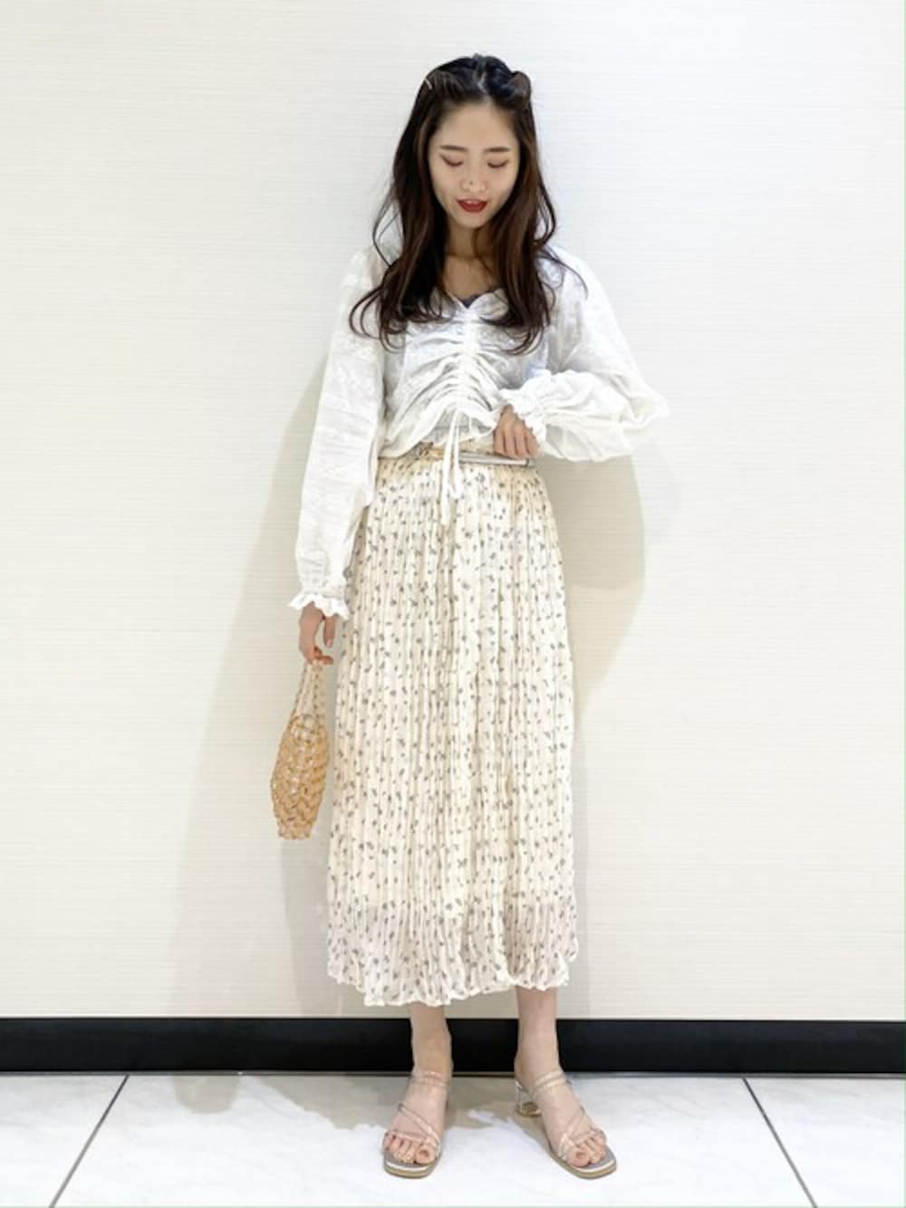 ホワイト系のシャツ/ブラウス、ブラウン系のキャミソール、ホワイト系のスカートを着用したレディースの春コーディネートの1枚目の写真