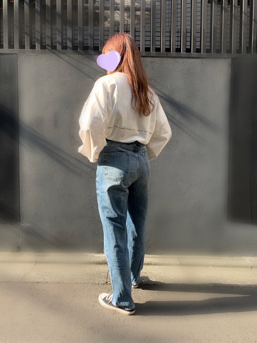 ブルー系のデニムパンツ、ブラック系のスニーカー、ホワイト系のTシャツ/カットソーを着用したレディースの秋コーディネートの1枚目の写真