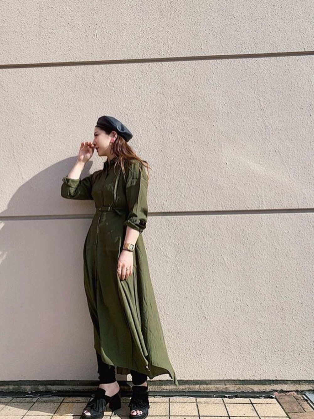 グリーン系のワンピース、ブラック系のハンチング/ベレー帽を着用したレディースの秋コーディネートの1枚目の写真