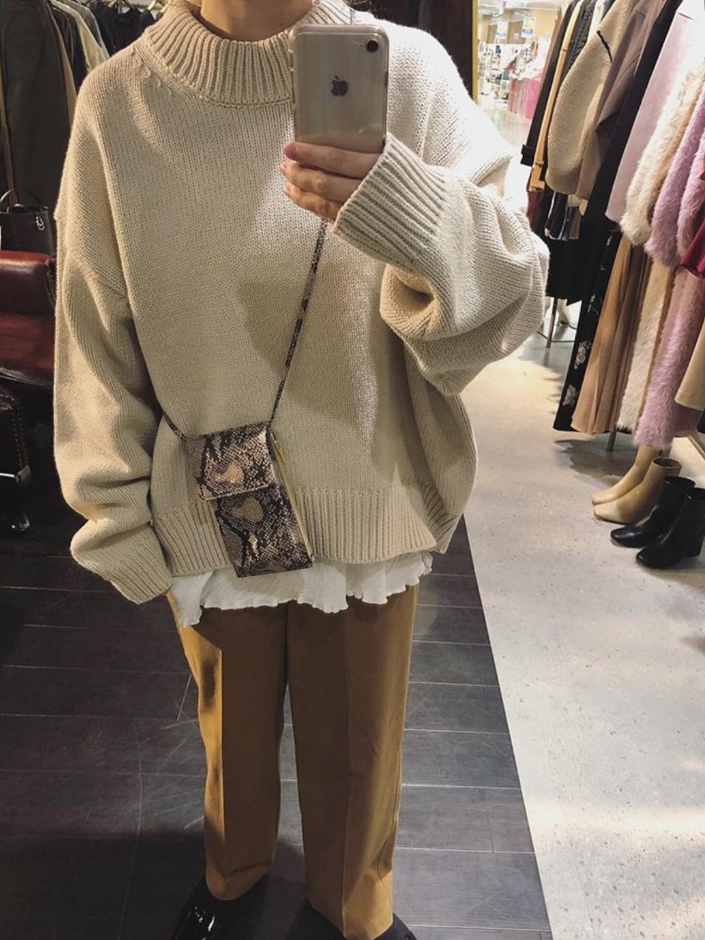 ベージュ系のニット/セーター、ホワイト系のTシャツ/カットソー、ベージュ系のパンツを着用したレディースの秋コーディネートの1枚目の写真