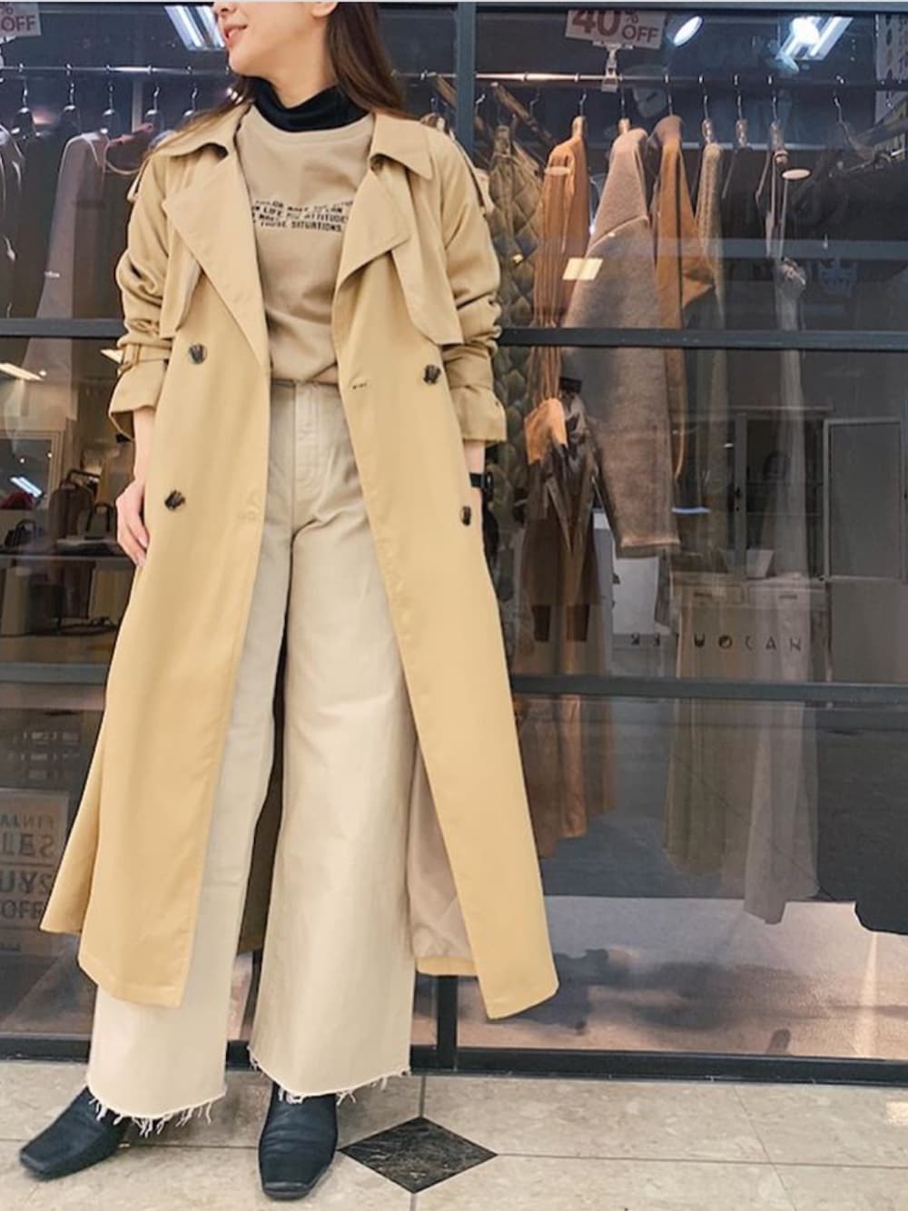 ベージュ系のトレンチコート、ベージュ系のデニムパンツ、ブラウン系のTシャツ/カットソーを着用したレディースの冬コーディネートの1枚目の写真