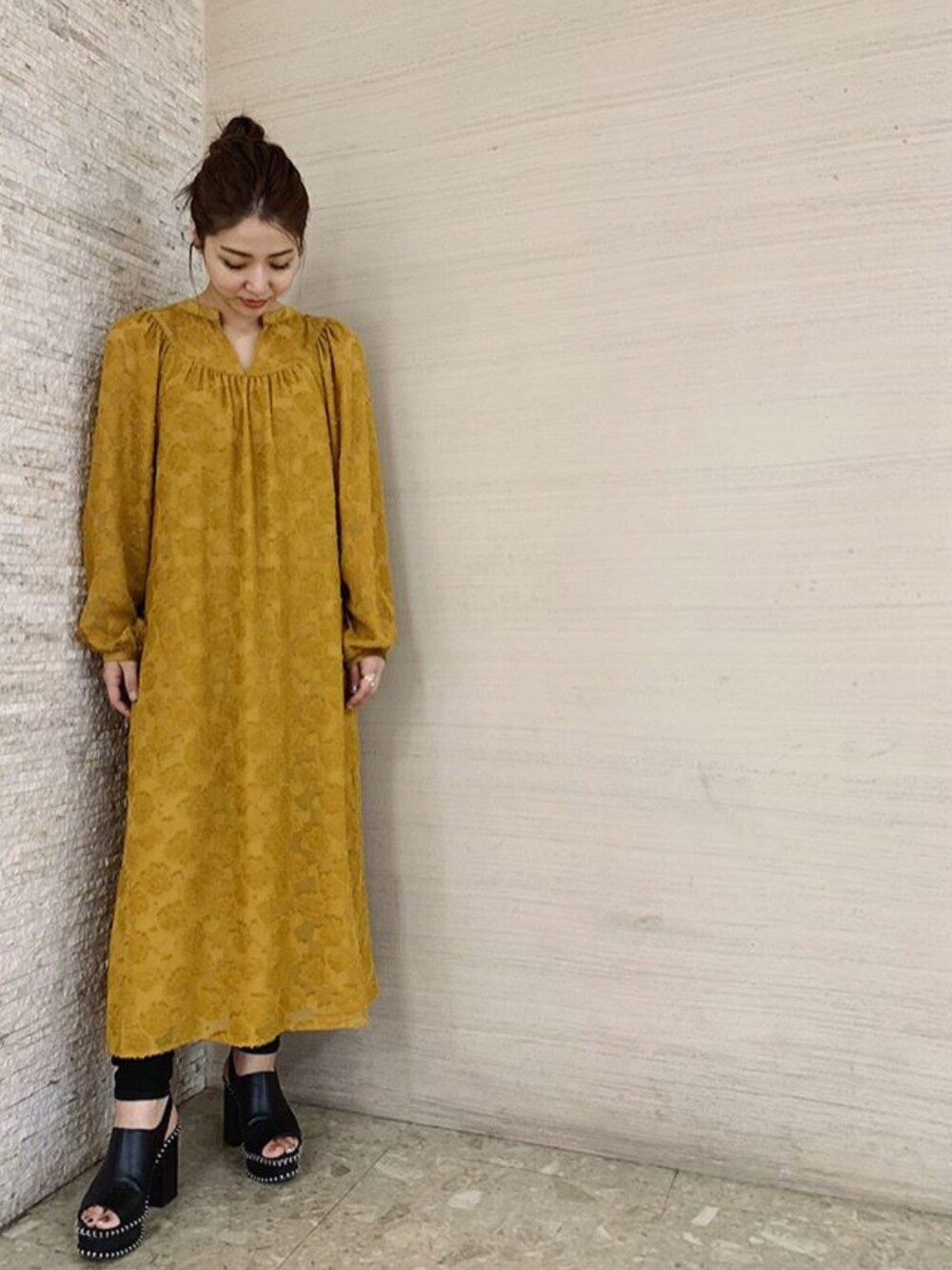 イエロー系のワンピースを着用したレディースの秋コーディネートの1枚目の写真