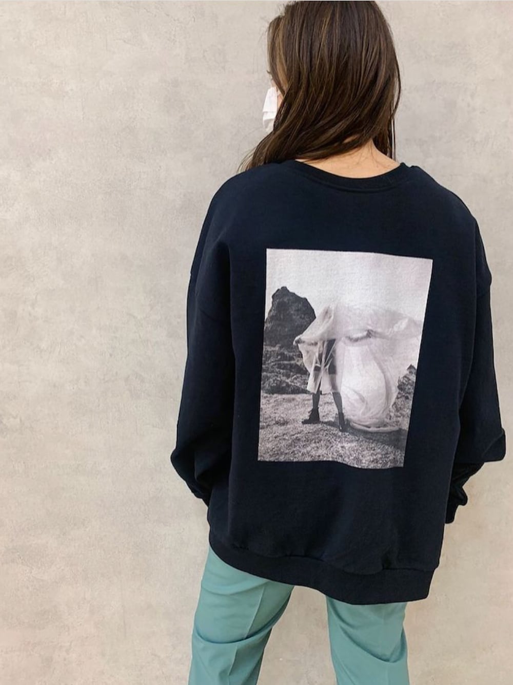 ブラック系のスウェット、ブルー系のスラックスを着用したレディースの冬コーディネートの1枚目の写真