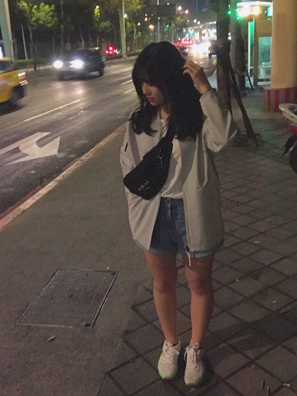 ブラック系のボディバッグ/ウエストポーチ、グレー系のナイロンジャケット、ホワイト系のTシャツ/カットソーを着用したレディースの春コーディネートの1枚目の写真