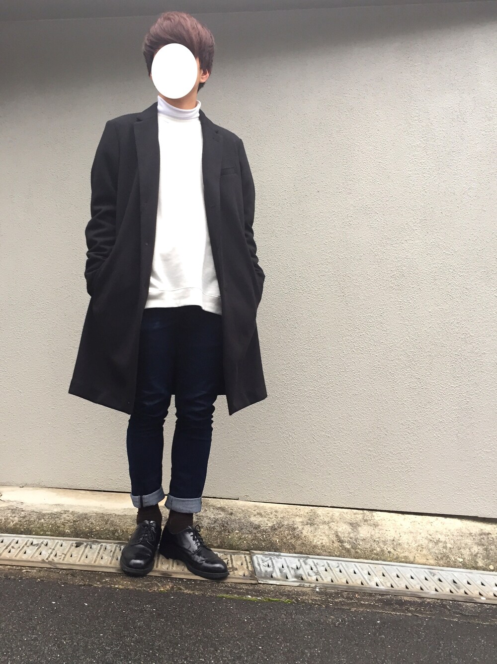 ブラック系のチェスターコート、ホワイト系のTシャツ/カットソー、ブラック系のスウェットを着用したメンズの冬コーディネートの1枚目の写真