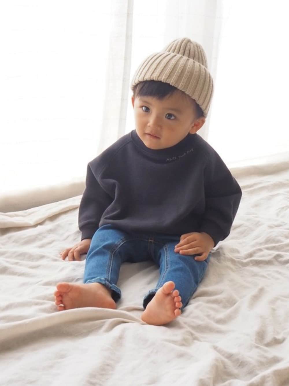 ブルー系のデニムパンツ、グリーン系のスウェットを着用したキッズの秋コーディネートの1枚目の写真