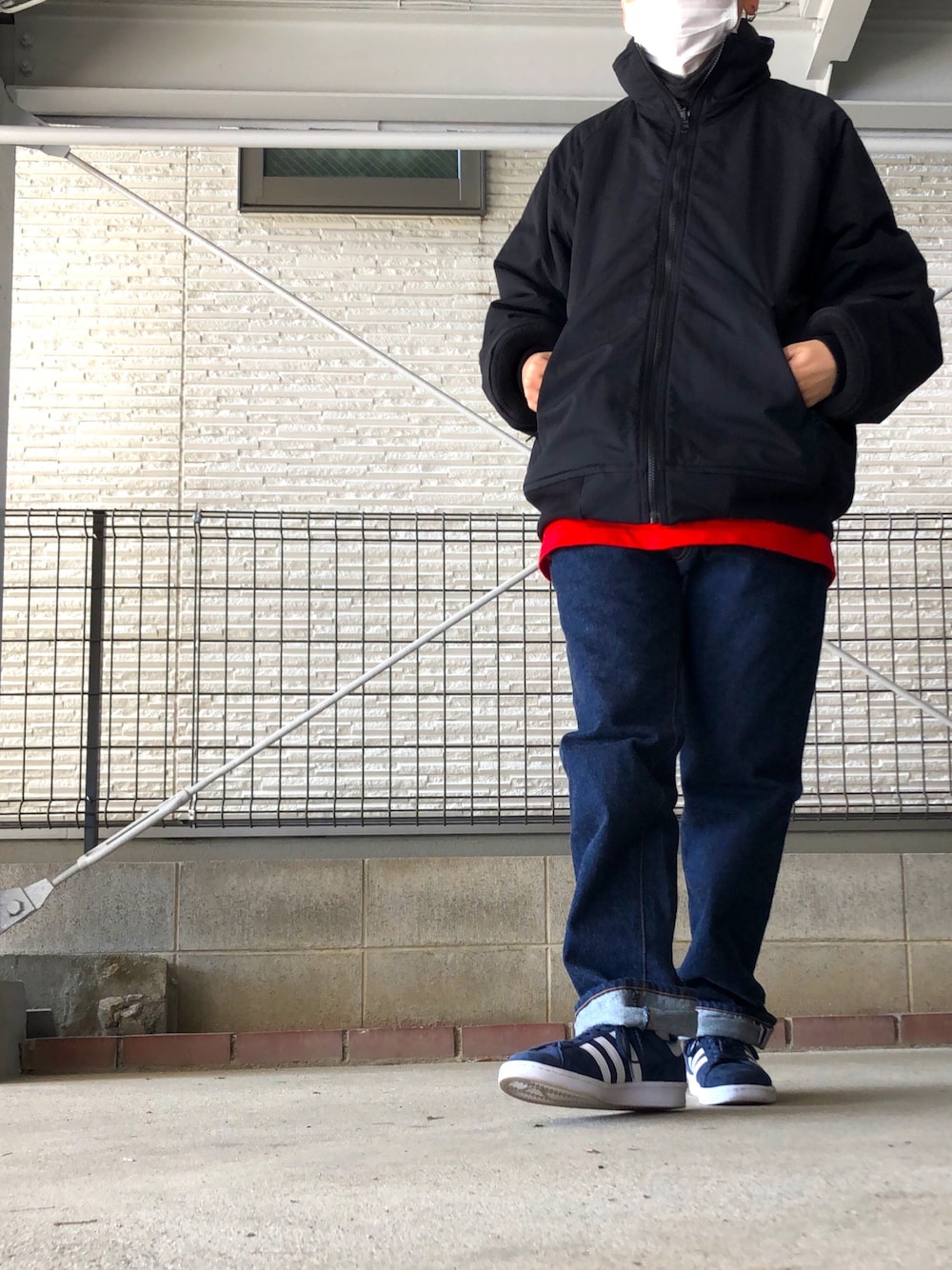 ブラック系のブルゾン、ブルー系のデニムパンツ、ブルー系のスニーカーを着用したレディースの冬コーディネートの1枚目の写真