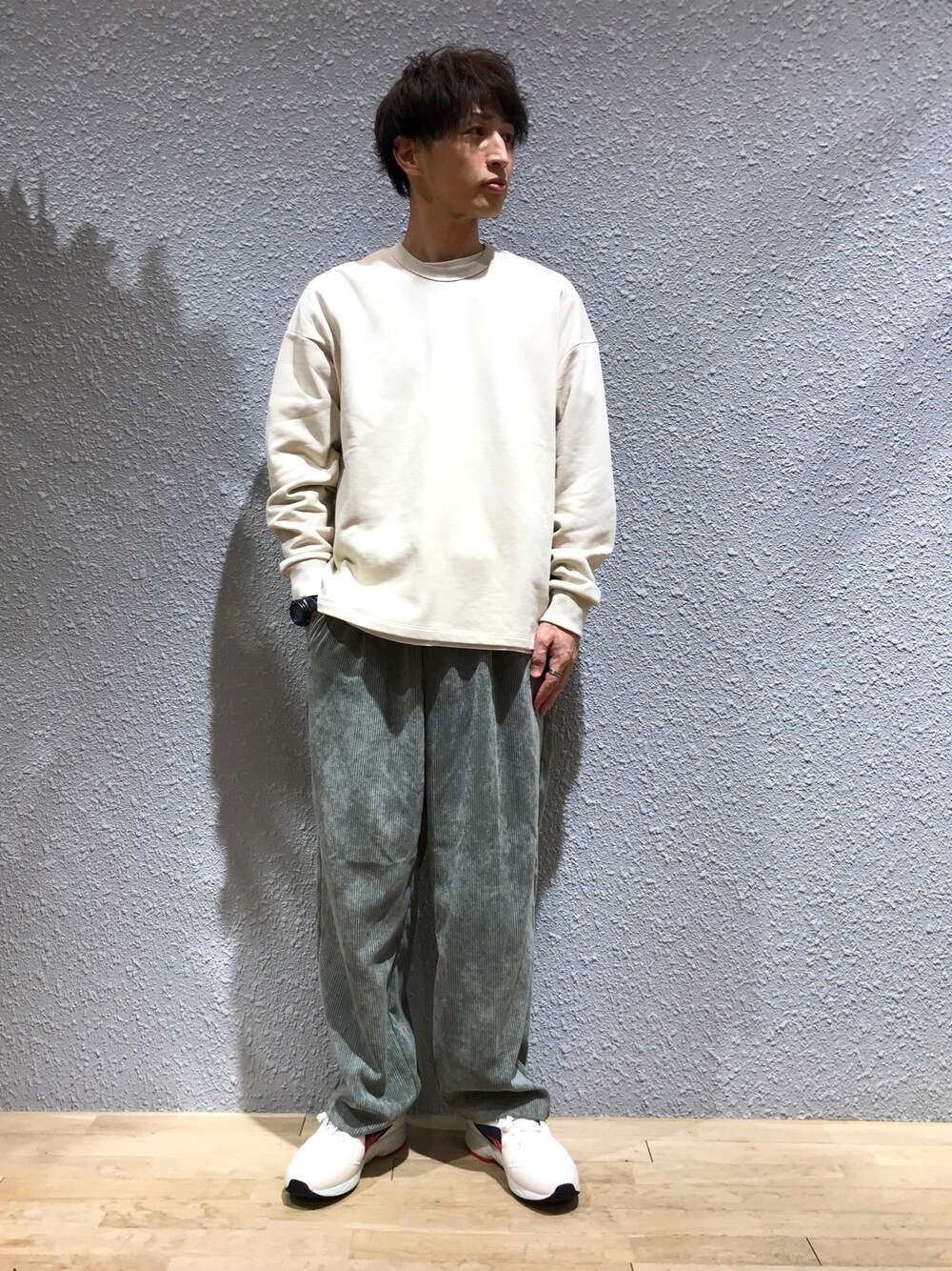 ホワイト系のスウェット、グリーン系のその他パンツ、ブルー系のスニーカーを着用したメンズの秋コーディネートの1枚目の写真