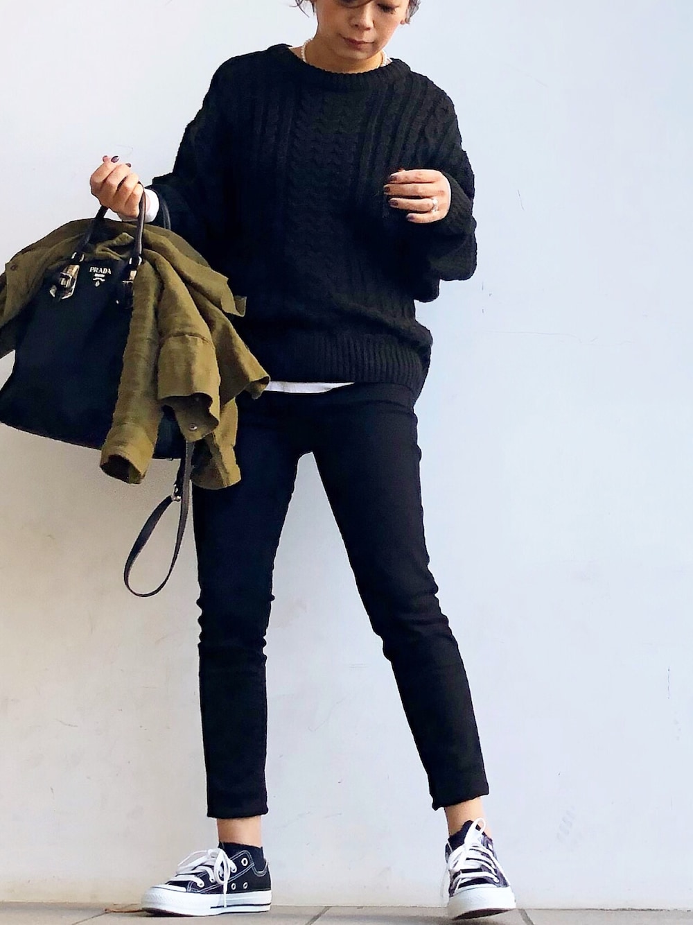 ブラック系のニット/セーター、ブラック系のパンツ、ブラック系のスニーカーを着用したレディースの秋コーディネートの1枚目の写真
