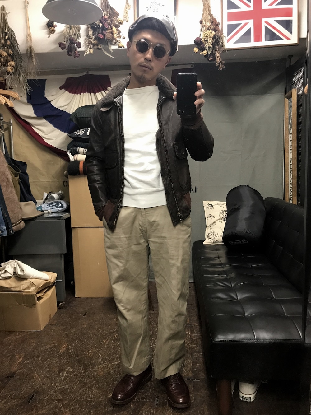 ブラウン系のミリタリージャケット、ベージュ系のチノパンツ、ブラウン系のドレスシューズを着用したメンズの秋コーディネートの1枚目の写真