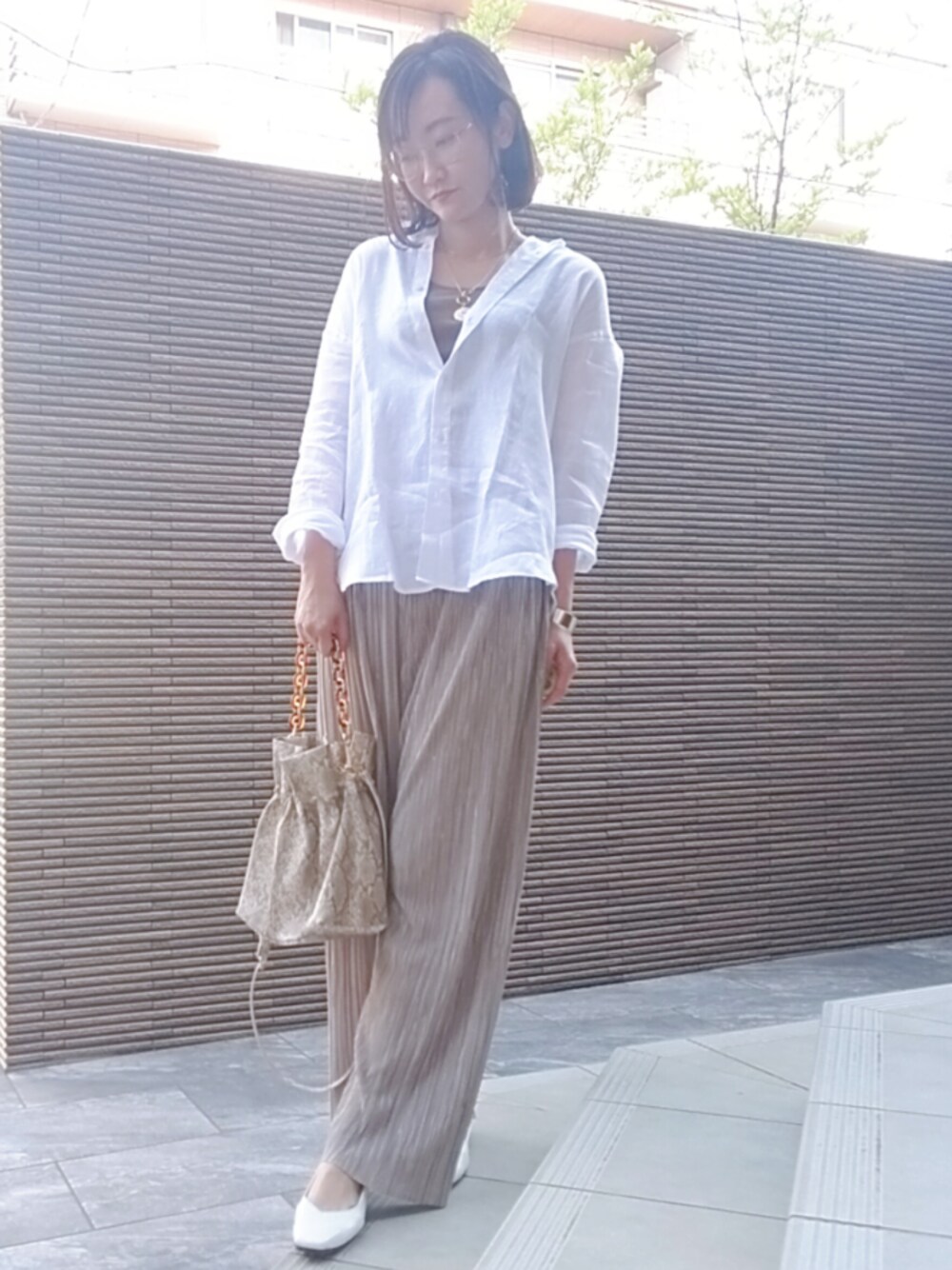 ホワイト系のシューズ、ベージュ系のパンツ、その他のショルダーバッグを着用したレディースの春コーディネートの1枚目の写真