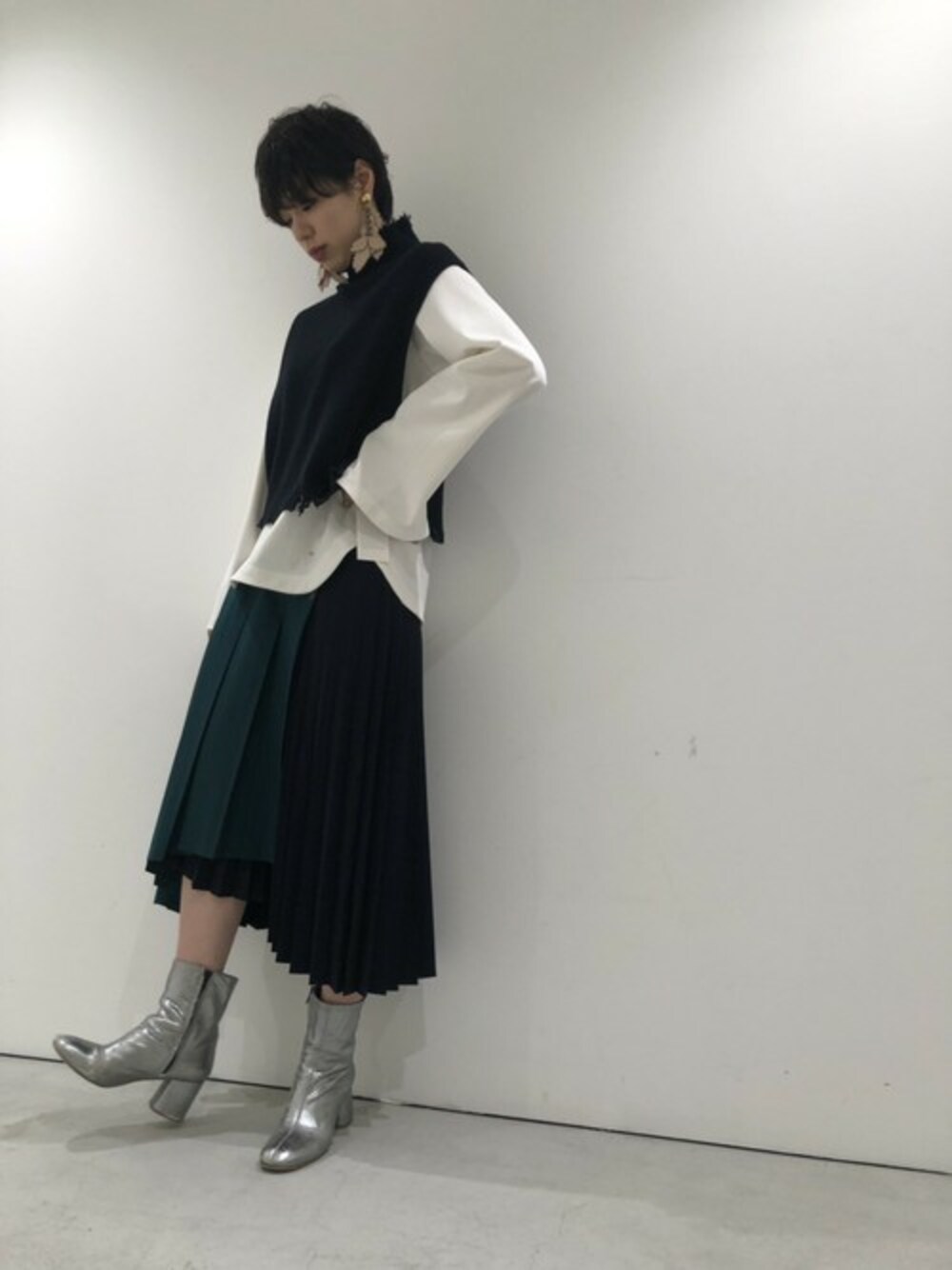 「ショートブーツ、レイヤードスタイル、ニットベスト、STUDIOUS、プリーツスカート、ラップスカート、秋コーデ、イアリング、THEDallas」｜「STUDIOUSの【STUDIOUS】バックスリット タートルネックニットベスト（ベスト、ブラック系）」を使った、Ohashi Erikaさん（レディース・167cm）の夏コーディネートの1枚目の写真