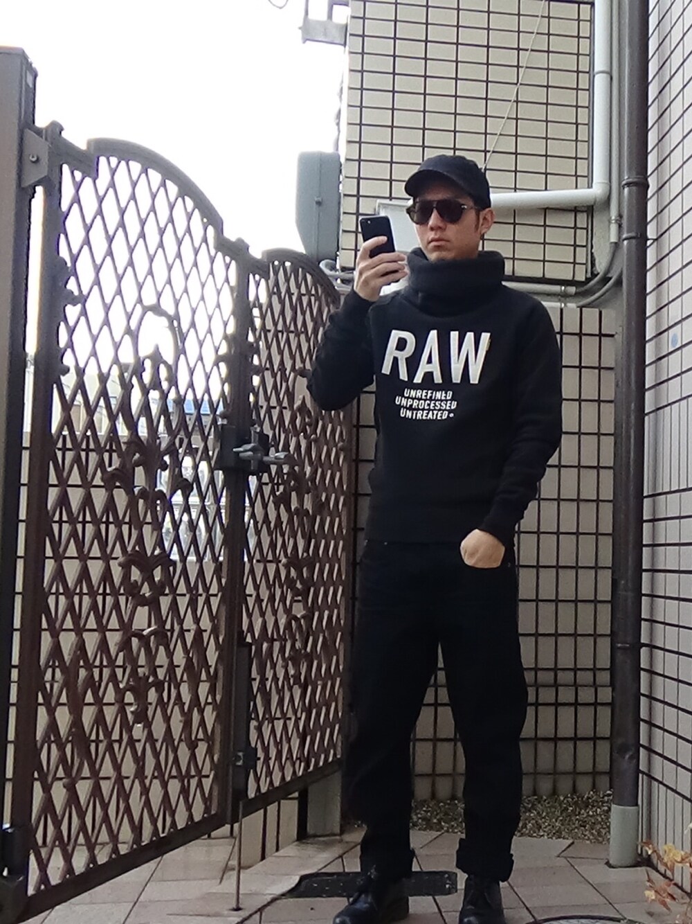 ブルー系のデニムパンツ、ブラック系のパーカー、ブラック系のドレスシューズを着用したメンズの冬コーディネートの1枚目の写真