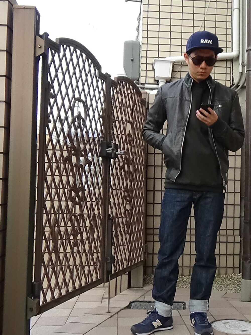 ブルー系のデニムパンツ、グリーン系のパーカー、ブルー系のスニーカーを着用したメンズの冬コーディネートの1枚目の写真