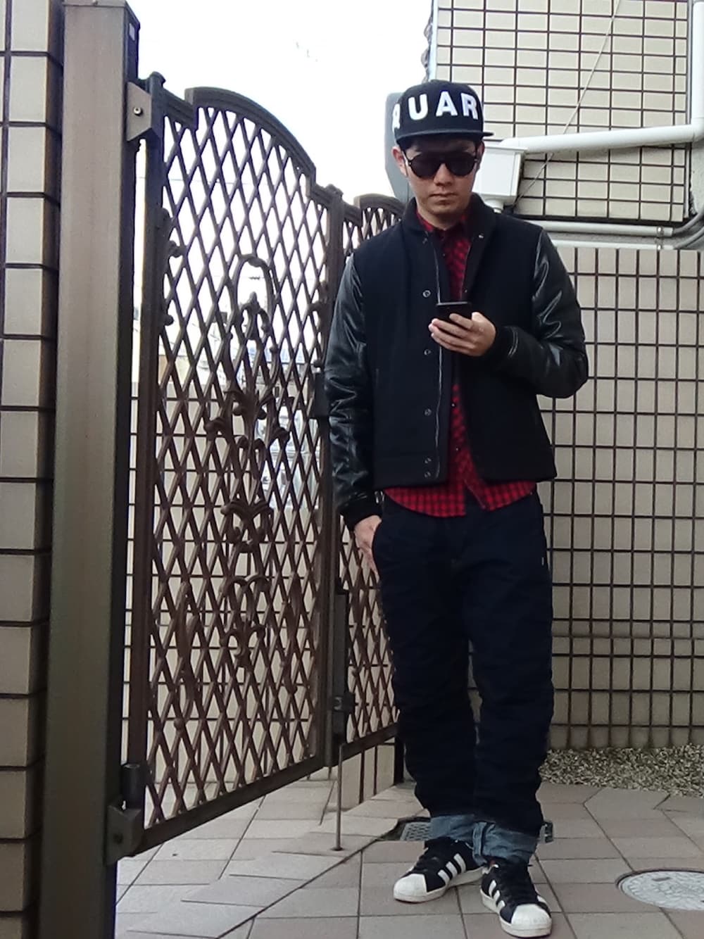 ブルー系のデニムパンツ、ブラック系のスニーカー、レッド系のシャツ/ブラウスを着用したメンズの冬コーディネートの1枚目の写真