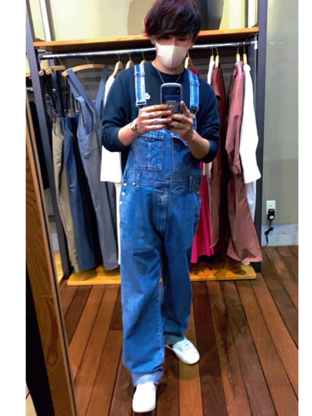 ホワイト系のスニーカー、ブルー系のサロペット/オーバーオール、ブラック系のスウェットを着用したメンズの春コーディネートの1枚目の写真