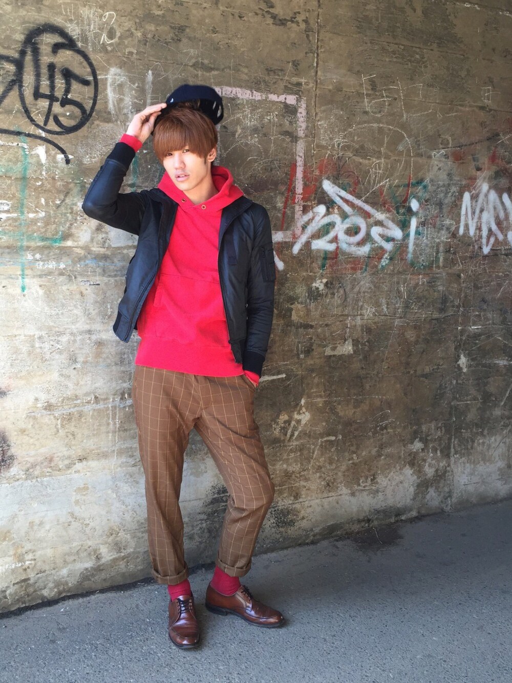 ブラウン系のスラックス、ブラック系のキャップを着用したメンズの秋コーディネートの1枚目の写真