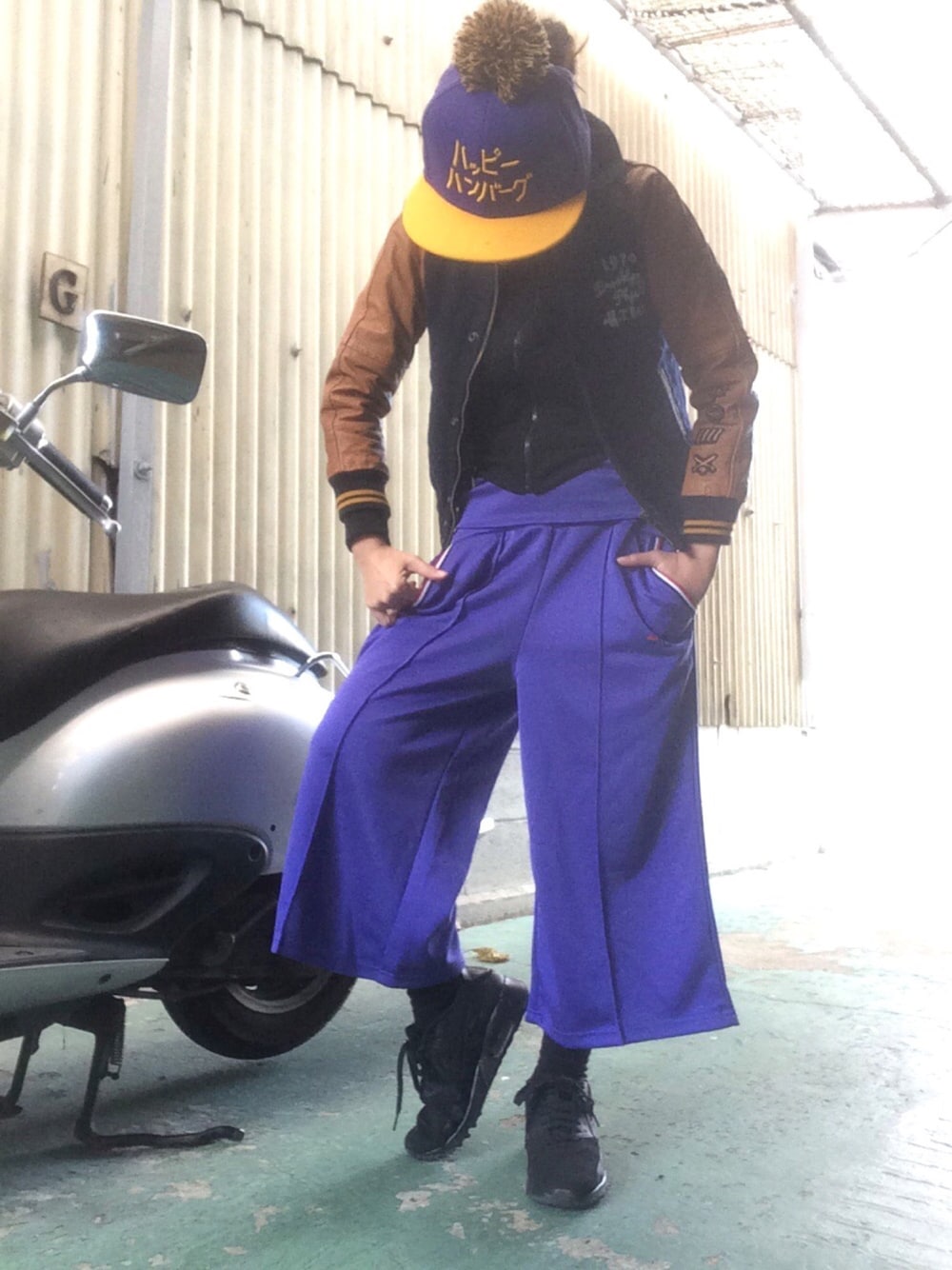 ブラック系のスニーカー、パープル系のパンツ、ブルー系のスタジャンを着用したレディースの冬コーディネートの1枚目の写真