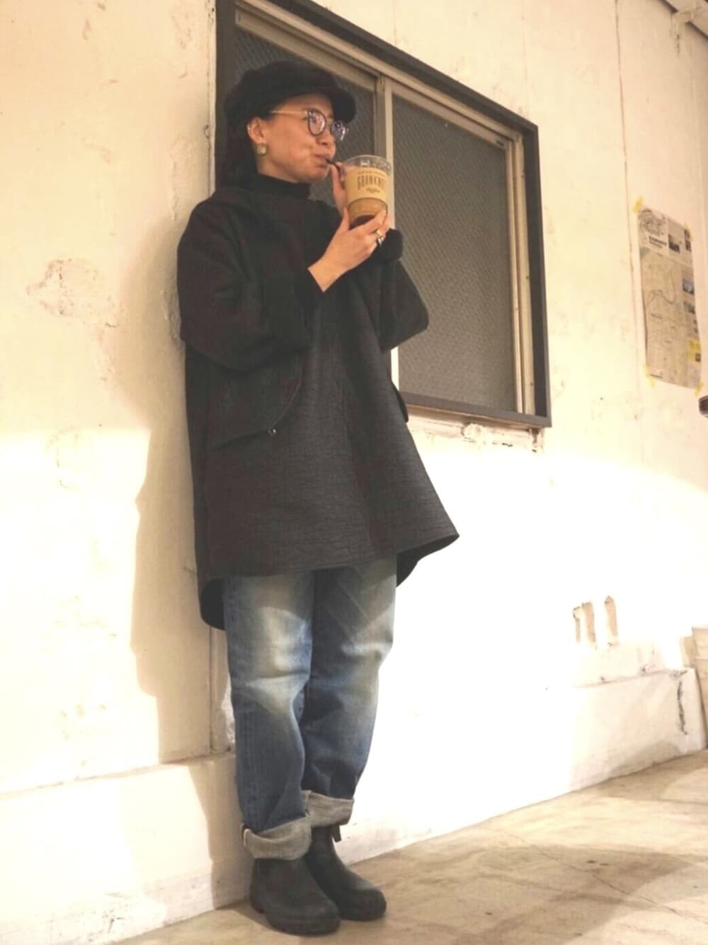 ブラック系のブーツ、ブルー系のデニムパンツ、ブラック系のパーカーを着用したレディースの冬コーディネートの1枚目の写真