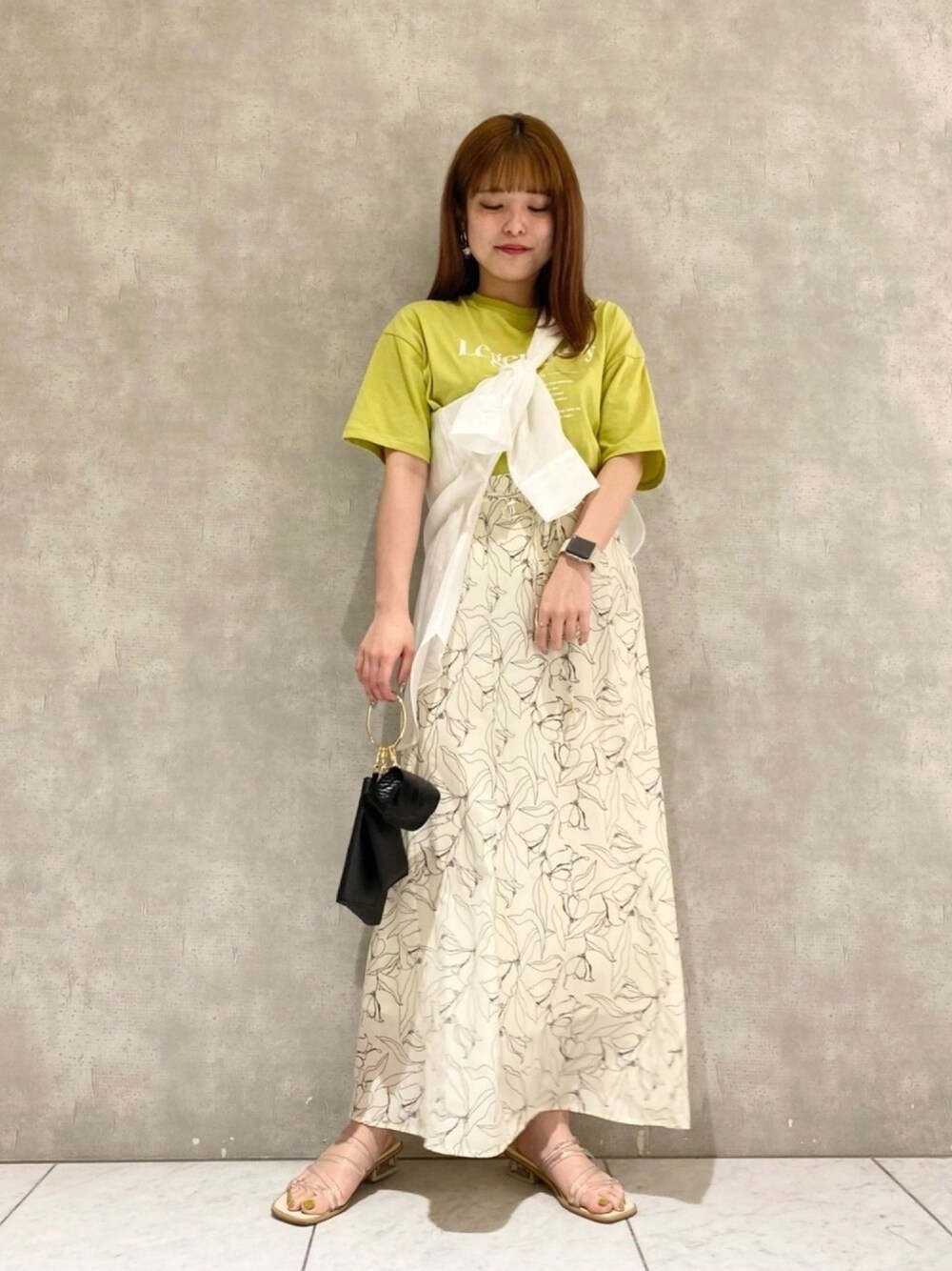 「オトナカジュアル、シンプル、スカート、ビタミンカラー、シアーシャツ、クリアサンダル、サンダル、たすき掛け、休日コーデ、ホワイトコーデ」｜「mysty womanのデザインロゴTシャツ 947456（Tシャツ/カットソー、グリーン系）」を使った、お こ めさん（レディース・155cm）の春コーディネートの1枚目の写真