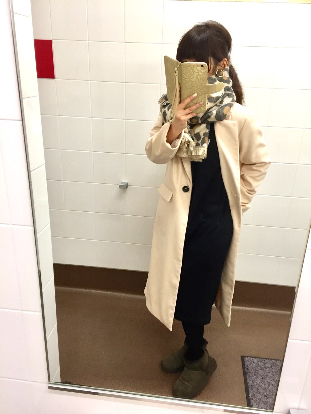 ホワイト系のチェスターコート、ブラック系のワンピース、ブラウン系のブーツを着用したレディースの冬コーディネートの1枚目の写真