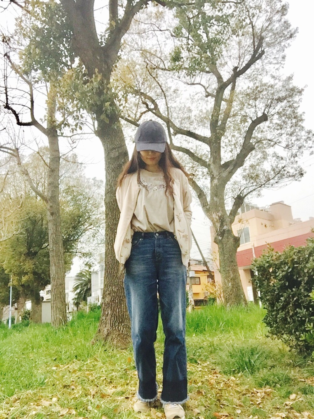 ホワイト系のブルゾン、グレー系のTシャツ/カットソー、ブルー系のデニムパンツを着用したレディースの春コーディネートの1枚目の写真