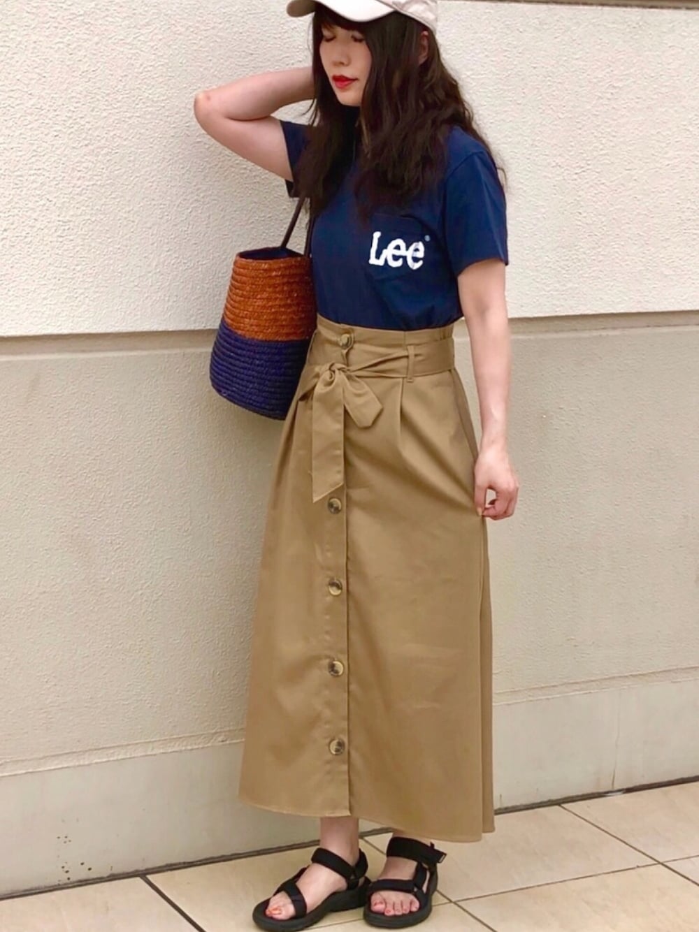 ベージュ系のスカート、ブルー系のTシャツ/カットソー、ブラック系のサンダルを着用したレディースの春コーディネートの1枚目の写真