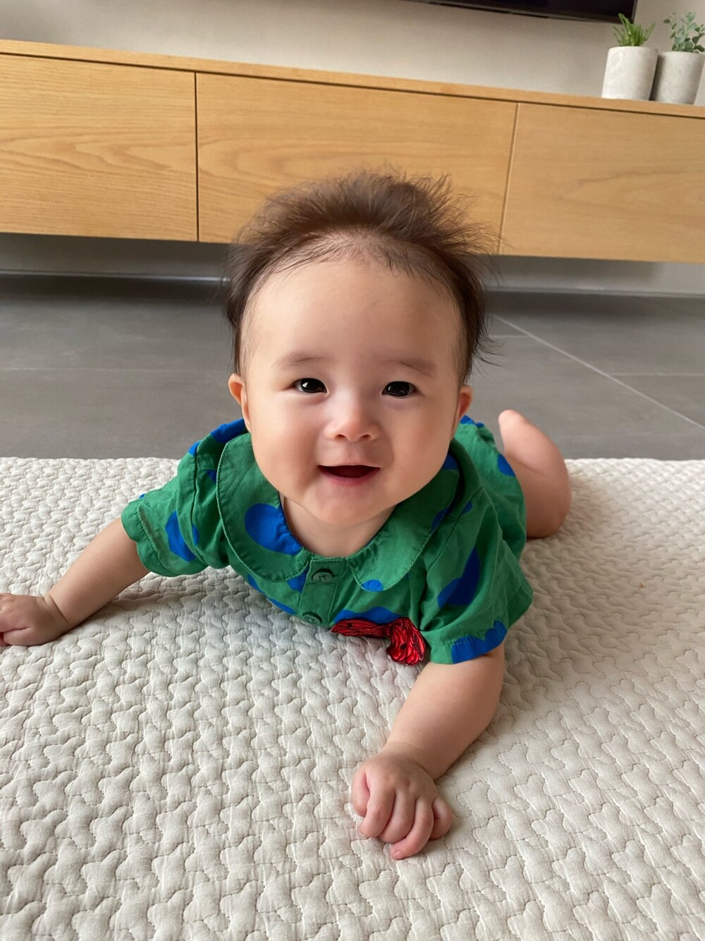 グリーン系のロンパースを着用したキッズの秋コーディネートの1枚目の写真