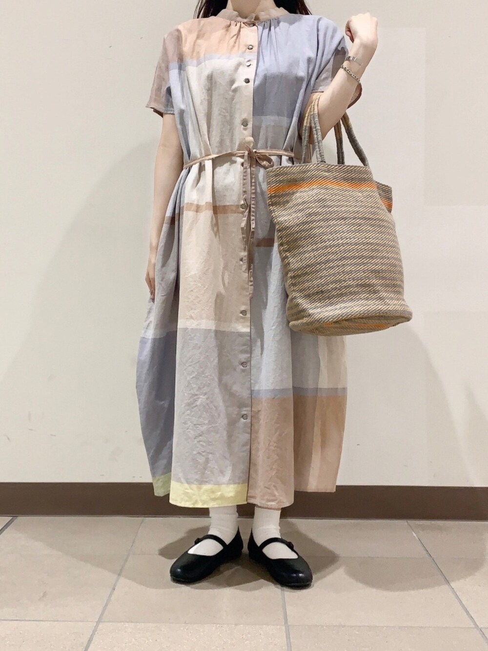 ベージュ系のワンピースを着用したレディースの春コーディネートの1枚目の写真