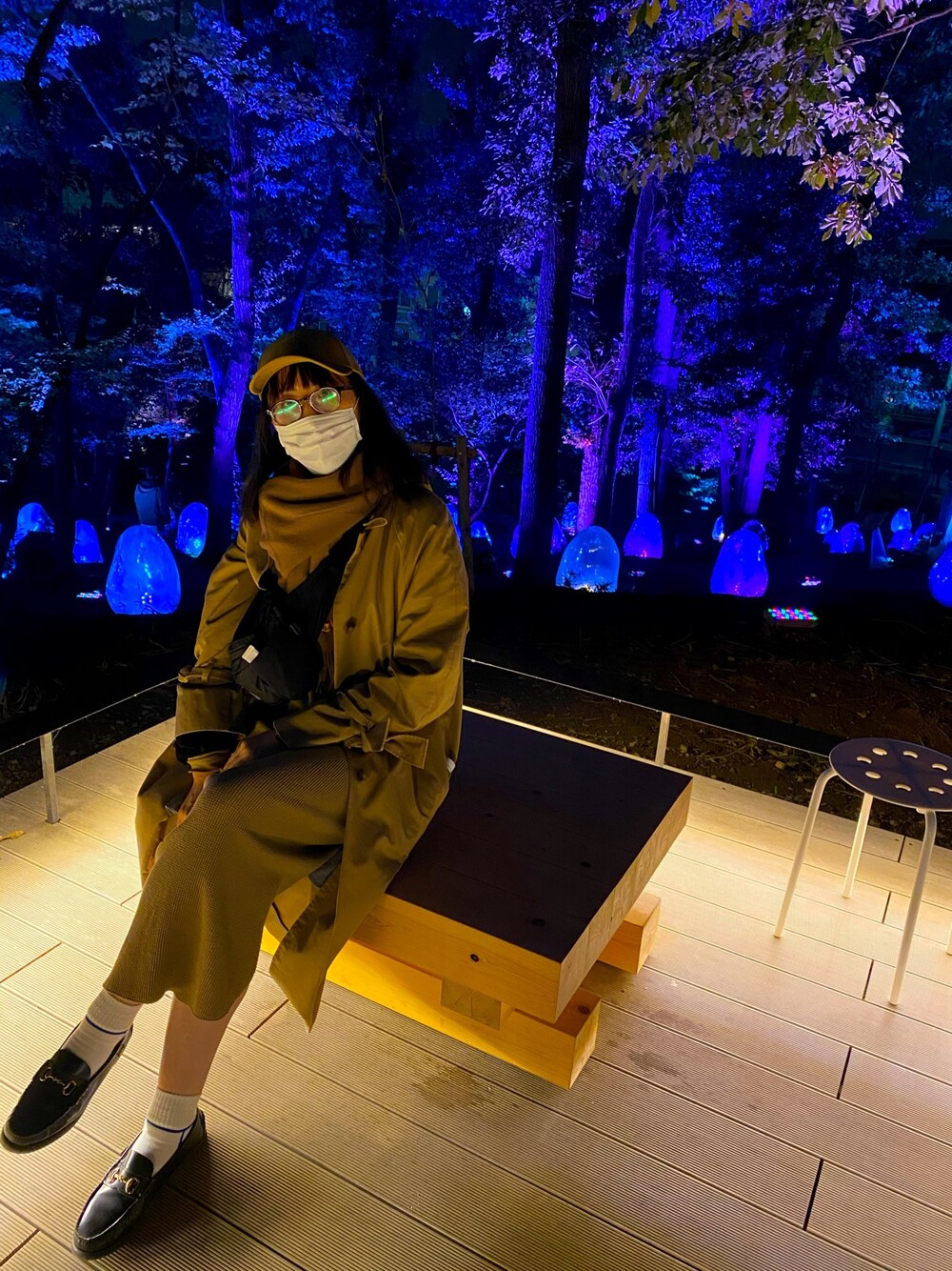 ベージュ系のステンカラーコート、ベージュ系のワンピース/ドレス、ブラック系のローファーを着用したレディースの秋コーディネートの1枚目の写真