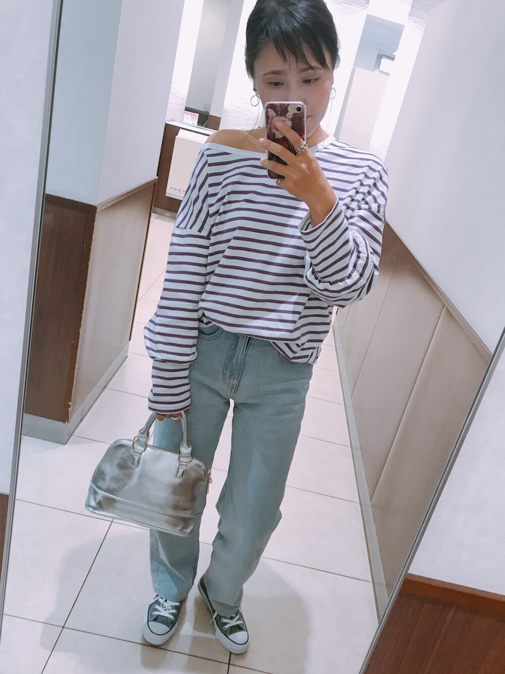 パープル系のTシャツ/カットソー、ブルー系のデニムパンツ、グレー系のスニーカーを着用したレディースの秋コーディネートの1枚目の写真