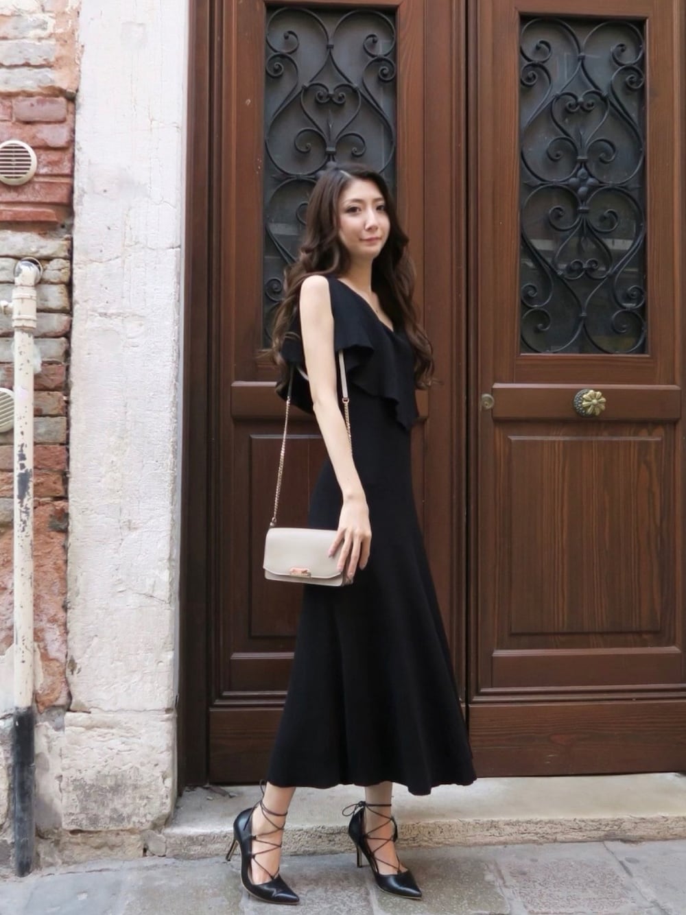 ブラック系のワンピース、ベージュ系のショルダーバッグを着用したレディースの夏コーディネートの1枚目の写真