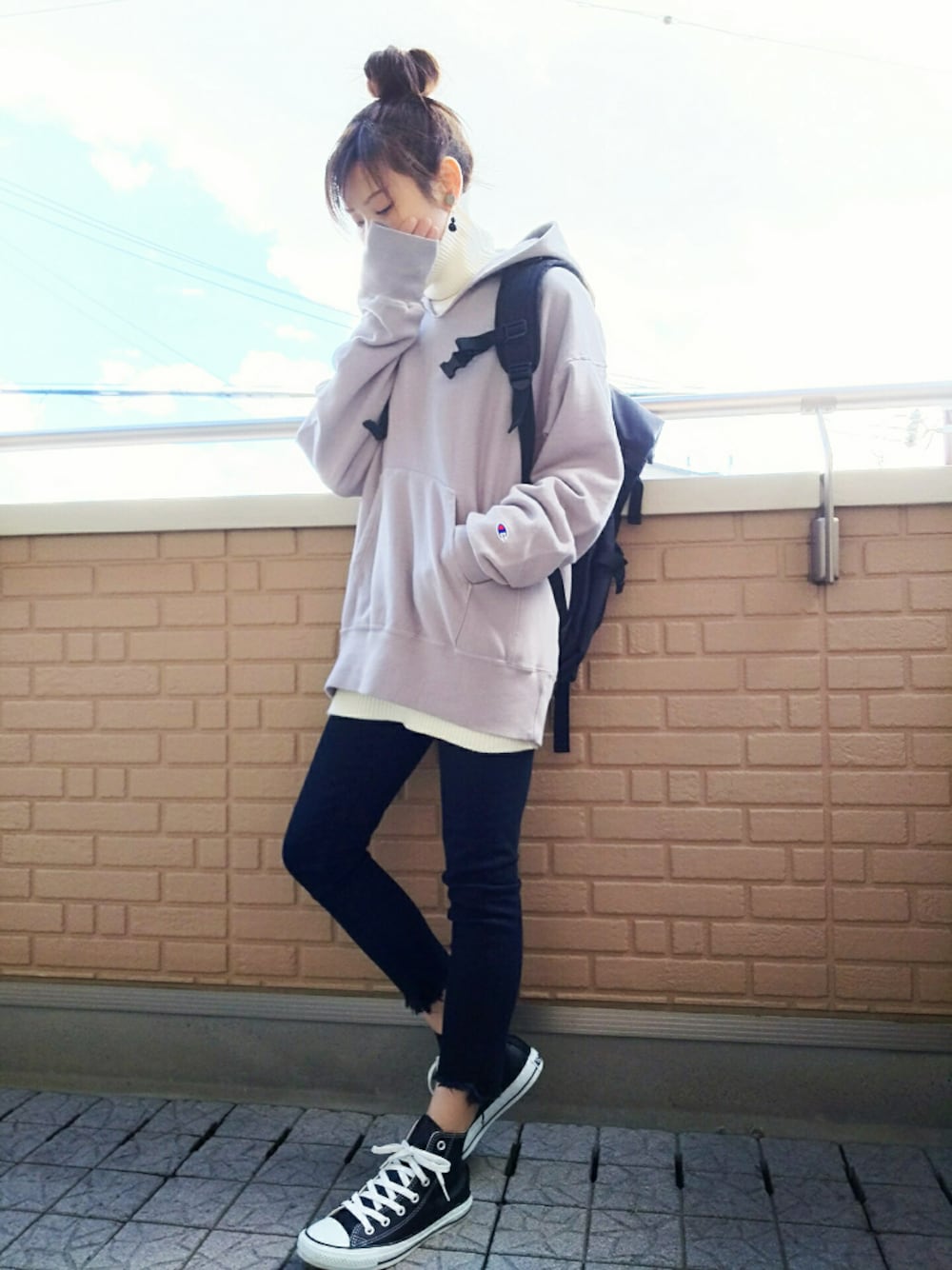 ホワイト系のニット/セーター、ブラック系のデニムパンツ、ブラック系のスニーカーを着用したレディースの冬コーディネートの1枚目の写真